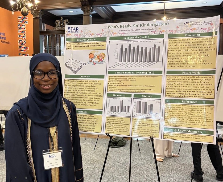 Taslim S. beside a research poster